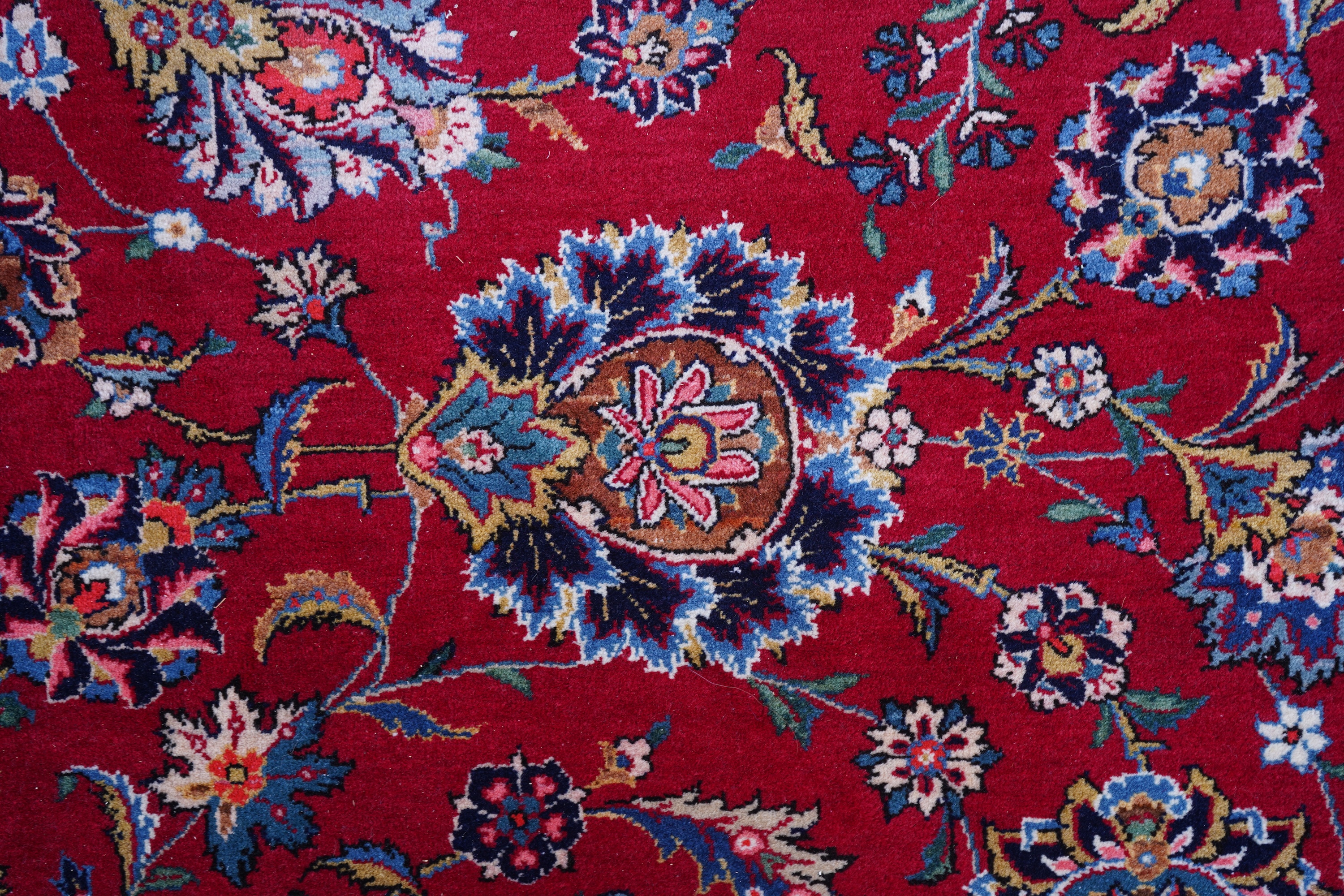 A Kashan burgundy ground carpet